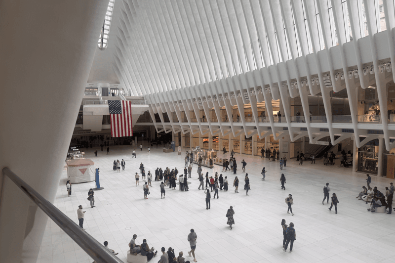 Two large American flags hang from within The Oculus in the World Trade Center in downtown Manhattan on September 11, 2026. (Shalina Chatlani/ Stateline)